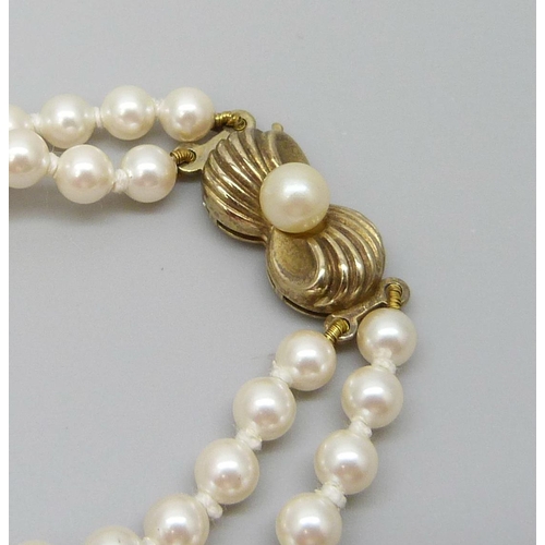 7101 - A two strand pearl necklace with a silver gilt clasp, 30g, 42cm