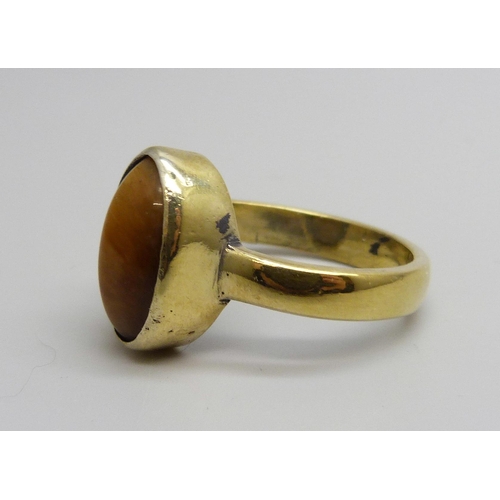 7129 - A silver gilt tiger's eye cabochon ring, V