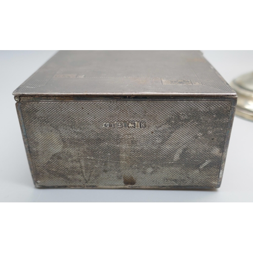 7366 - A silver cigarette box, 517g with liner, and a pair of candlesticks marked 'Sterling, Weighted & Rei... 