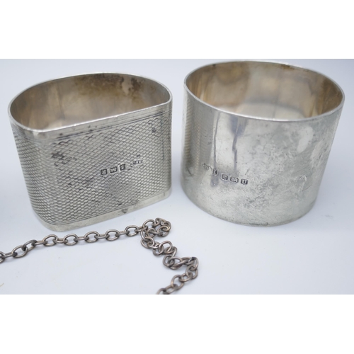 7376 - Four silver napkin rings, a silver ashtray and a silver port label, 224g