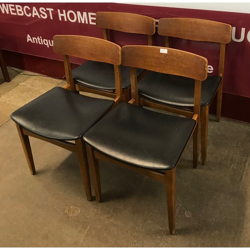 58 - A set of four teak and black vinyl dining chairs