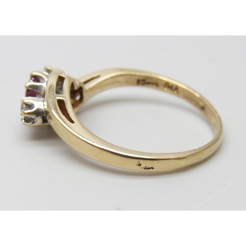 7033 - A 9ct gold, three stone ruby and diamond ring, 2.3g, M