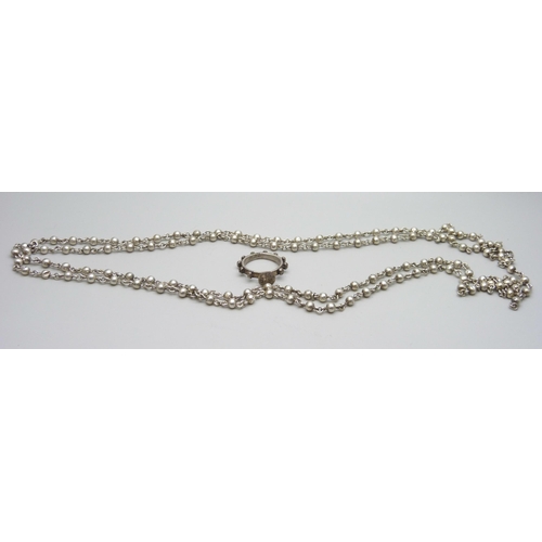 7061 - A c1900 long white metal guard chain, 53g, and a plated ring/seal