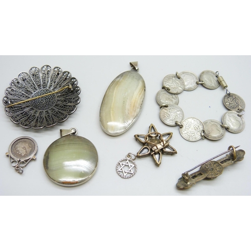 7070 - Two silver mounted stone pendants, two Egypt detail brooches, a coin bracelet, etc.