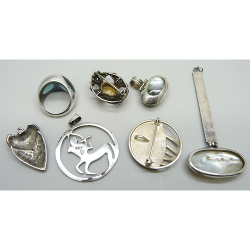 7075 - A silver circular pendant/brooch, four other silver pendants, one other brooch and a silver ring siz... 