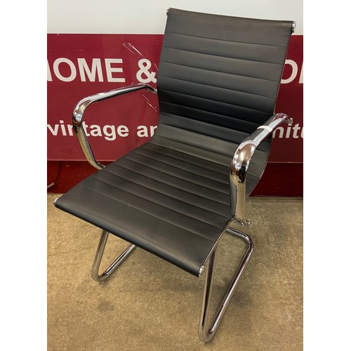 63 - An Eames style chrome and faux black leather cantilever desk chair