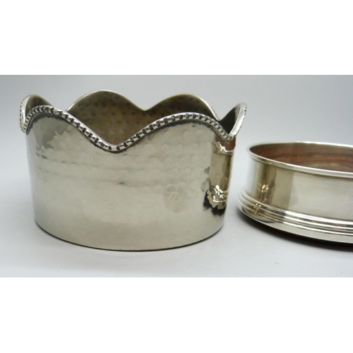 7141 - A silver coaster, diameter 9cm, and a hammered bottle stand, diameter 10.5cm