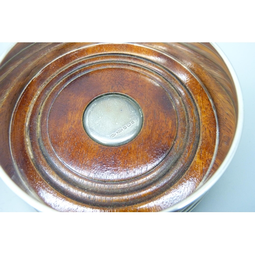 7141 - A silver coaster, diameter 9cm, and a hammered bottle stand, diameter 10.5cm