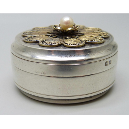 7156 - A circular silver pill box with filigree detail and set with a pearl, London 1984, 35g, diameter 41m... 