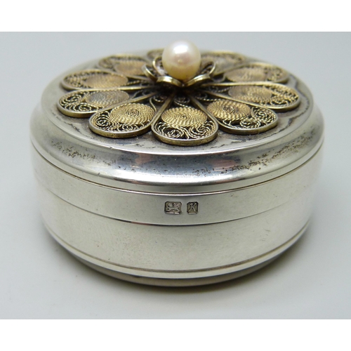 7156 - A circular silver pill box with filigree detail and set with a pearl, London 1984, 35g, diameter 41m... 