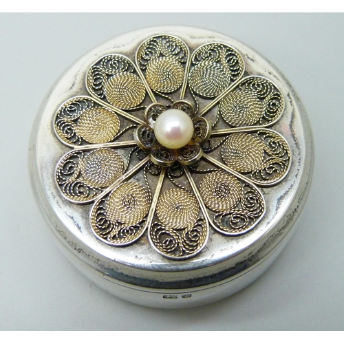 7156 - A circular silver pill box with filigree detail and set with a pearl, London 1984, 35g, diameter 41m... 