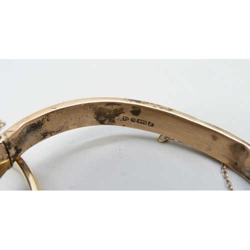 7169 - A 9ct gold bangle, 12.9g, a small silver bangle, a 9ct metal core bangle and one other