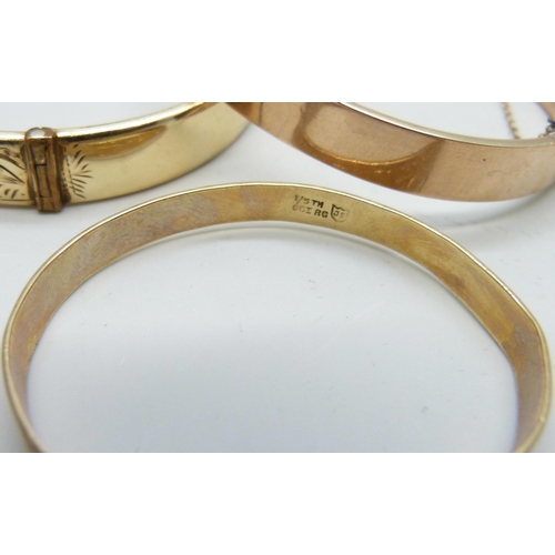 7169 - A 9ct gold bangle, 12.9g, a small silver bangle, a 9ct metal core bangle and one other