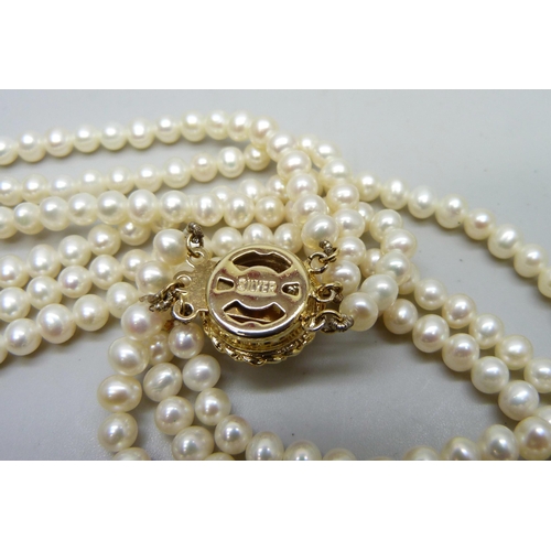 7173 - A triple row pearl necklace with silver gilt clasp