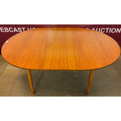 67A - A teak circular extending dining table and four chairs