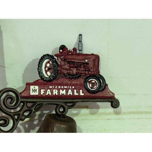 5153 - A McCormick Farmall tractor wall bracket with bell* This lot is subject to VAT