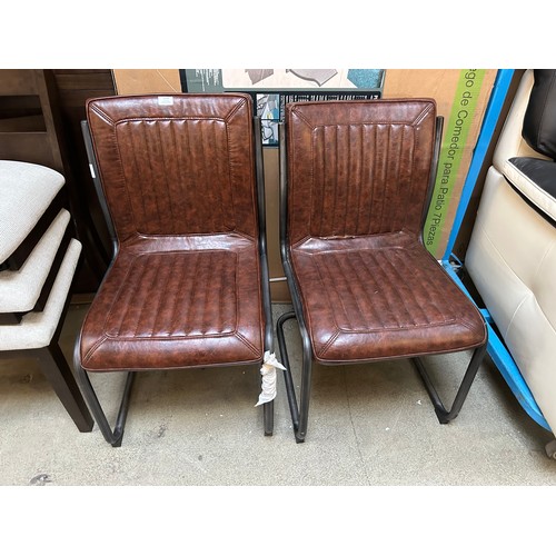 3316 - A pair of faux leather dining chairs (tear in fabric)  *This lot is subject to Vat