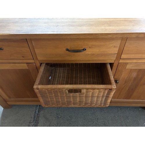 3287 - A solid oak 2 door 3 drawer sideboard with wine holder