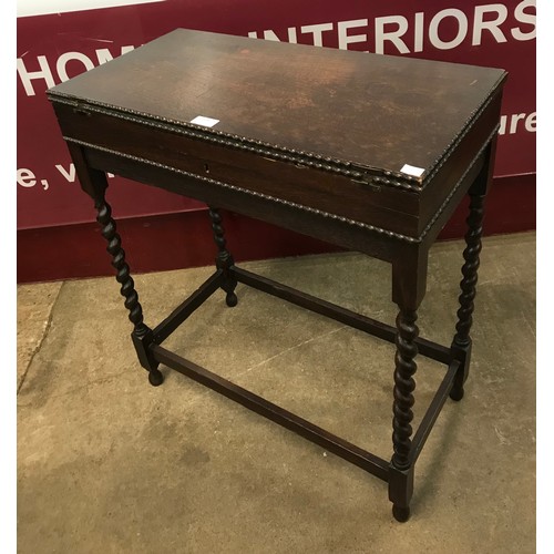 228 - An early 20th century oak barleytwist fold over games table/canteen of cutlery