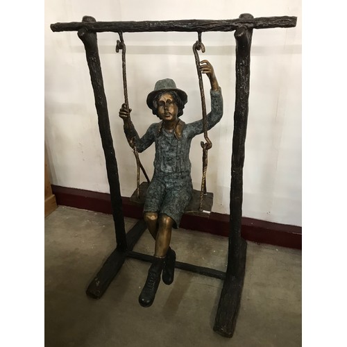 312 - A large bronze figure of a boy on a swing