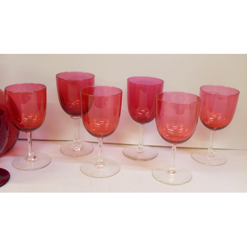 2051 - A cranberry glass carafe, (handle restored), six assorted cranberry wine glasses and two ruby glasse... 