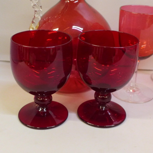 2051 - A cranberry glass carafe, (handle restored), six assorted cranberry wine glasses and two ruby glasse... 