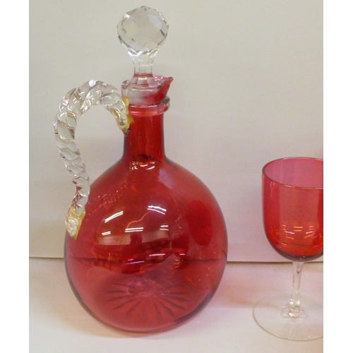 2051 - A cranberry glass carafe, (handle restored), six assorted cranberry wine glasses and two ruby glasse... 