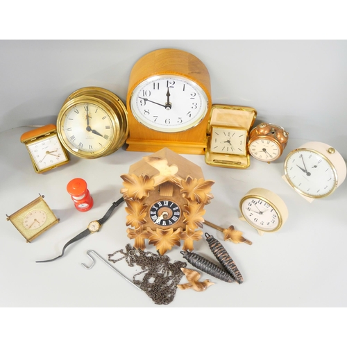 2231 - A box of nine clocks including wooden and brass examples, travel clocks and a cuckoo clock **PLEASE ... 