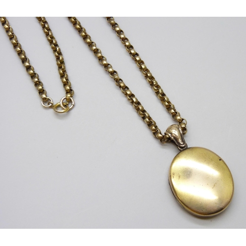 7022 - A gilt metal long guard chain and locket, 93cm