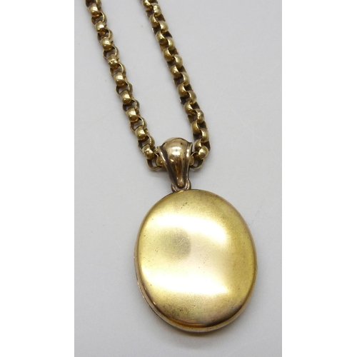 7022 - A gilt metal long guard chain and locket, 93cm