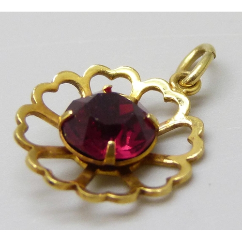 7023 - A 9ct gold pendant set with a red paste stone, 0.8g, 1.8cm