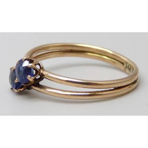 7037 - A 14k gold two stone sapphire crossover ring, 1.7g, K