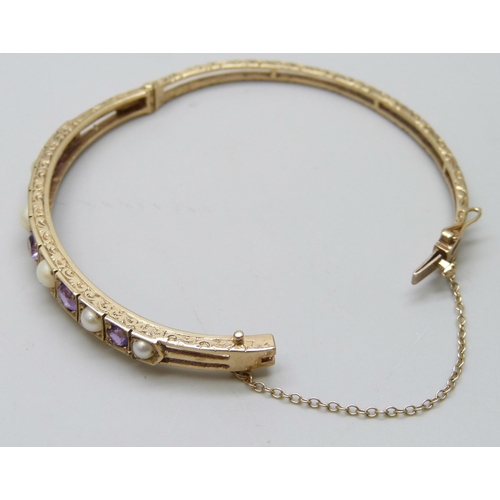 7038 - A 9ct gold, amethyst and pearl bangle, 11.8g, 5.9 x 5.1cm