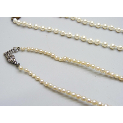 7042 - A string of pearls with a silver clasp, 41.5cm, 9.6g, and a string of faux pearls with a silver gilt... 