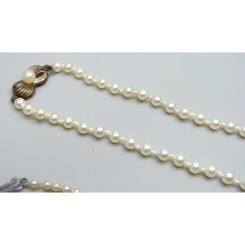 7042 - A string of pearls with a silver clasp, 41.5cm, 9.6g, and a string of faux pearls with a silver gilt... 