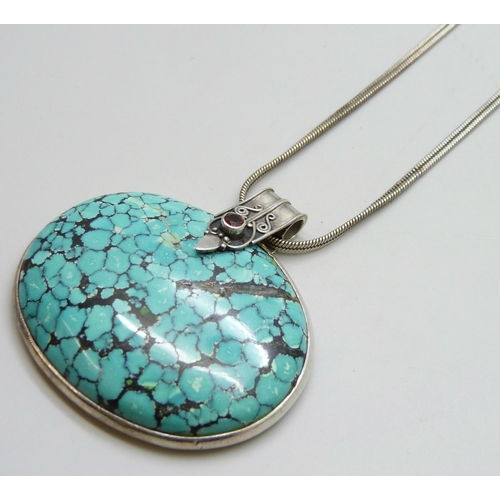 7050 - A large silver and turquoise Arts and Crafts style pendant on a silver chain, 70g, 6 x 6.3cm