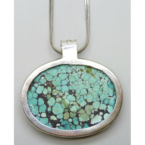 7050 - A large silver and turquoise Arts and Crafts style pendant on a silver chain, 70g, 6 x 6.3cm