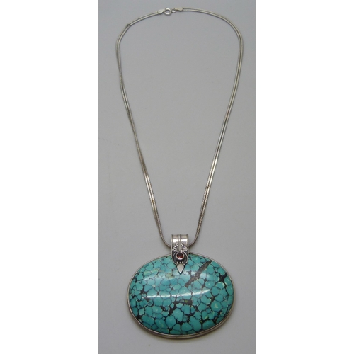 7050 - A large silver and turquoise Arts and Crafts style pendant on a silver chain, 70g, 6 x 6.3cm