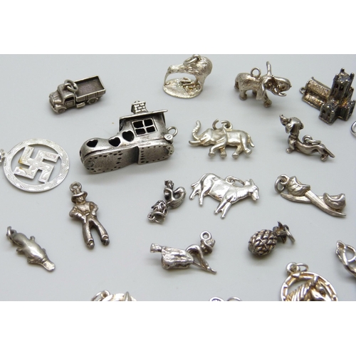 7055 - A collection of silver and white metal bracelet charms including a hallmarked shoe charm, opening to... 