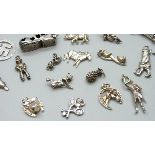 7055 - A collection of silver and white metal bracelet charms including a hallmarked shoe charm, opening to... 