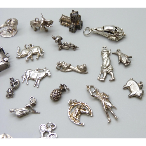 7055 - A collection of silver and white metal bracelet charms including a hallmarked shoe charm, opening to... 