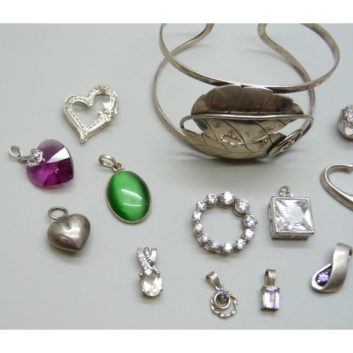 7063 - A silver bangle and a collection of silver pendants, 51g, together with two white metal pendants