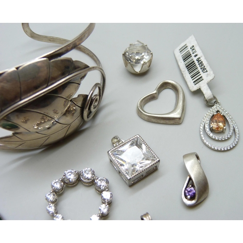 7063 - A silver bangle and a collection of silver pendants, 51g, together with two white metal pendants