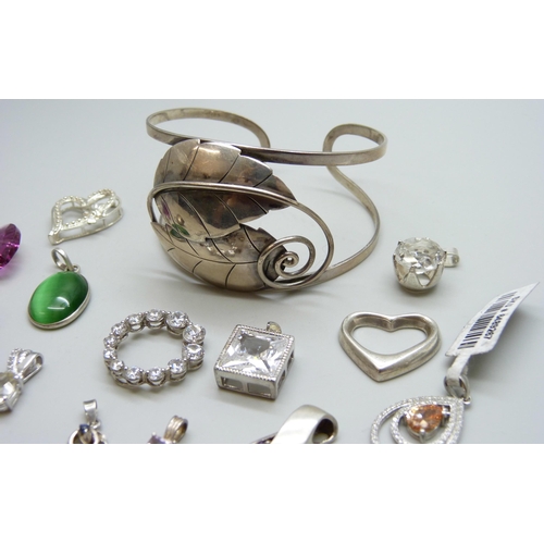 7063 - A silver bangle and a collection of silver pendants, 51g, together with two white metal pendants