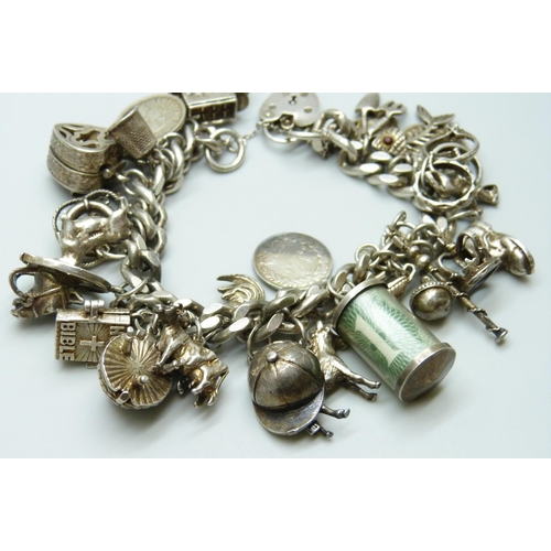 7065 - A silver charm bracelet with 28 silver and white metal charms, the padlock fastener Birmingham 1975,... 