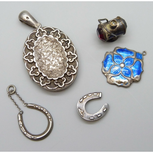 7066 - A Victorian silver locket, a silver and enamel pendant, a/f, a silver lamp charm, a silver horseshoe... 