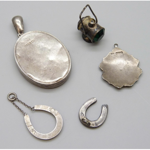 7066 - A Victorian silver locket, a silver and enamel pendant, a/f, a silver lamp charm, a silver horseshoe... 