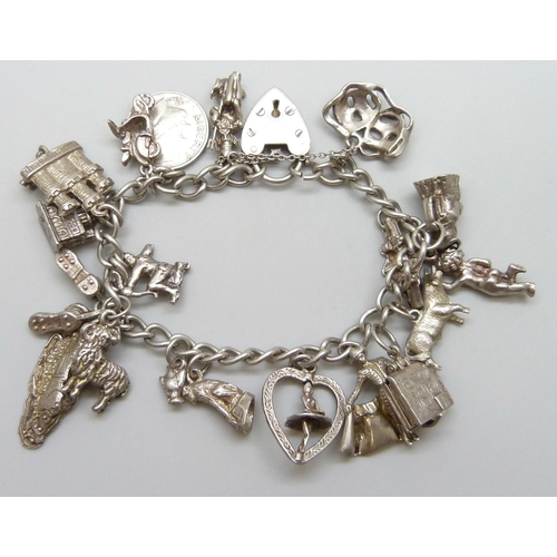 7071 - A silver charm bracelet with 18 silver and white metal charms, 59g