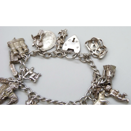 7071 - A silver charm bracelet with 18 silver and white metal charms, 59g