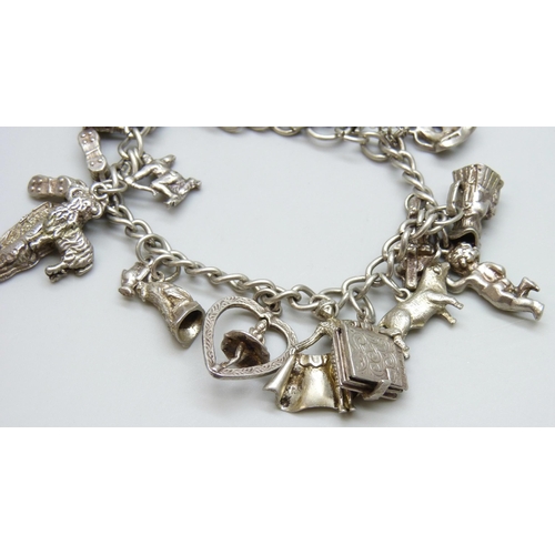 7071 - A silver charm bracelet with 18 silver and white metal charms, 59g